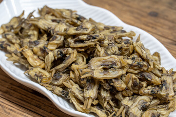 Dried razor clams in containers on wood grain countertops