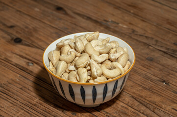 Dried cashew nuts in containers on wooden countertops