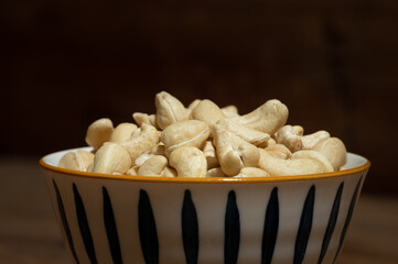 Dried cashew nuts in containers on wooden countertops