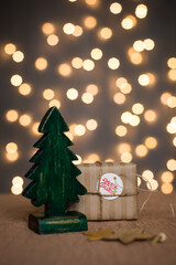 Wooden Christmas tree on a background of lights. Christmas, new year. Souvenir. Card