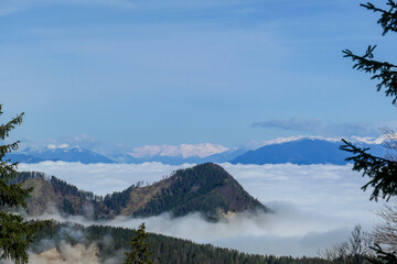 A panoramic view from the top of Alpine peak in Austria. The whole area is shrouded in thick...