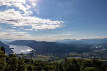 A view on the Lake Ossiach located in the heart of the Alps in Carinthia, Austria. The surface of the lake reflects golden sunbeams. The view is from a chapel on the hilltop of Oswaldiberg.