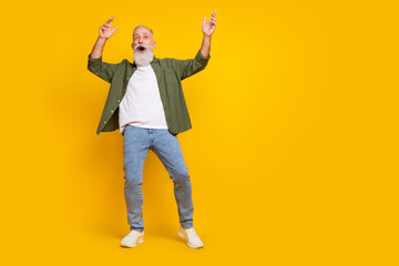 Full length body size photo of dancing senior man wearing casual clothes amazed surprised isolated on vivid yellow color background copyspace