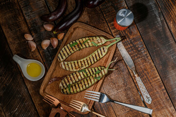 Fototapeta na wymiar Grilled eggplants in cutting board on wood background.