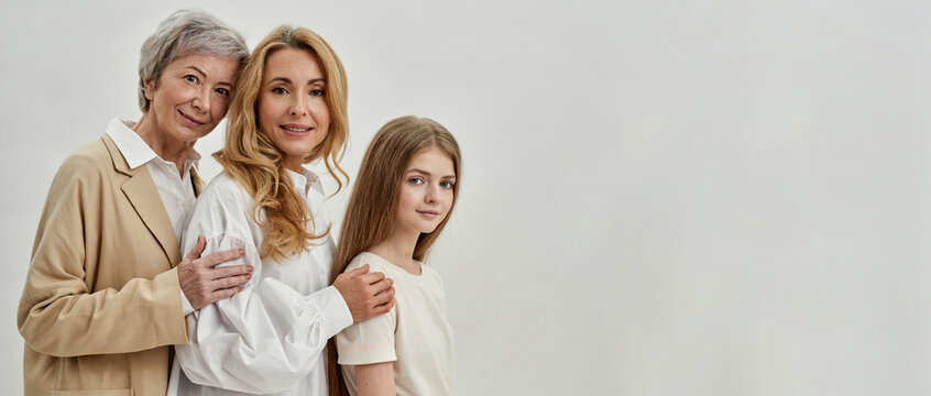 Side view of three females posing in white studio