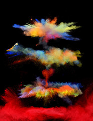 A vibrant colored powder paint cloud trio explodes in front of a black background to give off fantastic multi colors and forms.