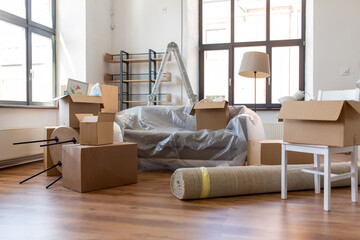 moving and real estate concept - boxes with stuff at new home