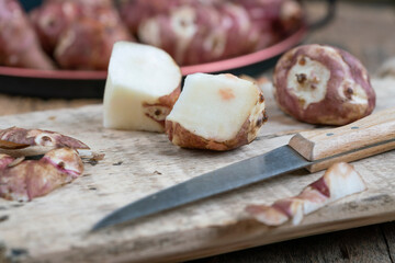 closeup Jerusalem artichokes halved on cutting board on wooden table