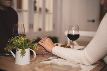 a wedding couple hold hands while waiting for food in a restaurant.Valentine's Day
