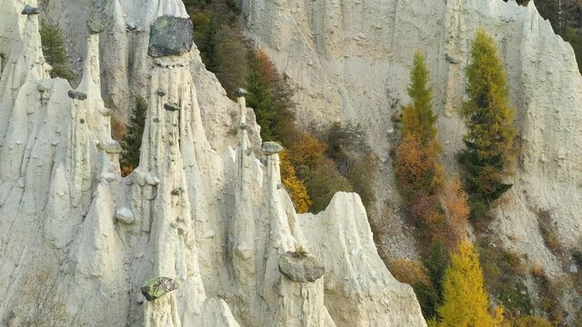 Aerial view on natural Earth Pyramids of Platten in autumn Dolomite Alps. Perca, Dolomites, Italy. UHD 4k drone video