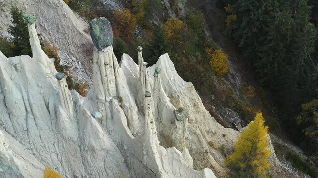 Aerial view on natural Earth Pyramids of Platten in autumn Dolomite Alps. Perca, Dolomites, Italy. UHD 4k drone video