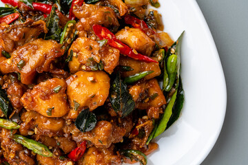 Ayam Tangkap, spices fried chicken original from Aceh, Indonesia. served with leaves such as temurui or curry leaves, pandan leaves and green chili, that are roughly chopped and fried crispy.