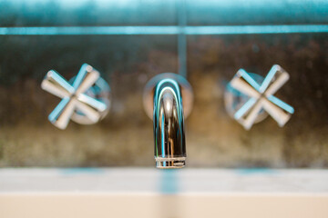Close up chrome metal tap in luxury bathroom wall background