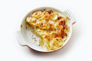 Delicious baked dish with potato and cream in ceramic pan on table