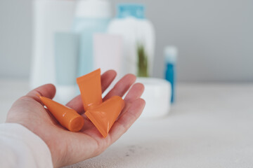 Female hand holding cosmetics in plastic packaging. Trash with used cosmetics plastic packaging. Plastic garbage. Save the planet 