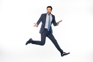 Fototapeta na wymiar excited businessman in suit jumping and gesturing on white.