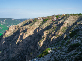 Fototapeta na wymiar Village on a high cliff. High mountain city on the rock. Mountain plateau with a village above a cliff. Dagestan.