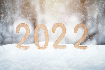 2022 plywood new year numbers stand in a snowdrift outdoors with snowflakes