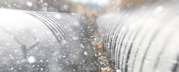 Metal pipeline in the street on a snowy day