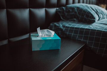 Close up of white tissue in blue paper box on the bedside table in the bedroom - obrazy, fototapety, plakaty