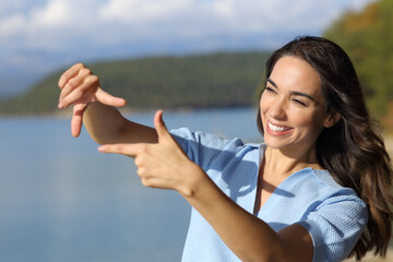Happy woman framing with hands in nature