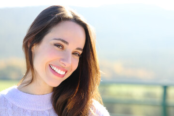 Happy woman with perfect smile looks at camera outside