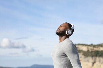 Man with black skin meditating listening audio guide