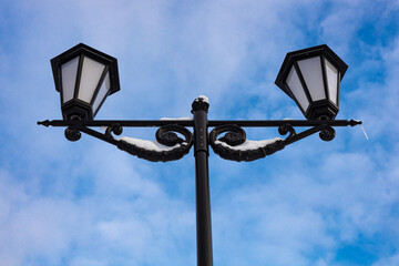 street lamp of black color against the blue sky in winter