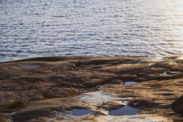 Beautiful natural Scandinavian landscape. Rocky shore at the Baltic sea with sunlight and water. Sunny late autumn or winter day in the nature in Sweden, Stockholm archipelago. Bjorno nature reserve