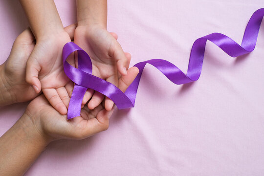 Hands holding Purple ribbons world cancer day concept