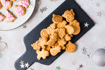 Freshly baked Christmas cookies are piled on a slate on a decorated table. Festive treat. Top view. Close-up