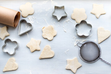 Top view of woman hands cooking a gingerbread cookie in the form of heart, star, cloud and flower. Christmas and New Year concept, festive preparations for winter hilodays
