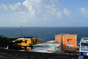 Fototapeta na wymiar A buildings on the San Juan cost with blue sea and passenger ship at the horizon