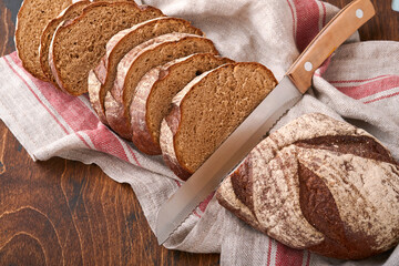 Fresh homemade rye bread. Traditional spelled sourdough bread cut into slices on a rustic wooden...