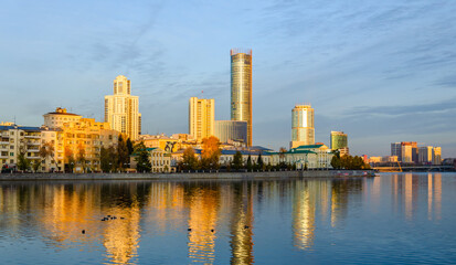 Fototapeta na wymiar High-rise buildings in the golden hour on the lake shore.