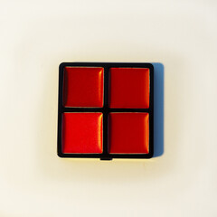 Mini palette with warm red shades of lip gloss. Isolated image on a white background. Nobody. New cosmetics. Collection of four shades.