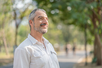 Portrait of senior man smiling in the park.Retirement relax concept