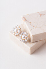 Pearl earrings on marble background. Modern jewelry. Earrings for bride