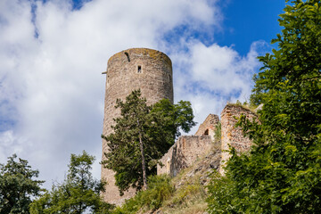 Fototapeta na wymiar Tocnik, Central Bohemia, Czech Republic, 31 July 2021: Ruins of medieval castle Zebrak on hill, old stronghold with stone tower, ancient gothic fortress at summer sunny day, landmark in countryside