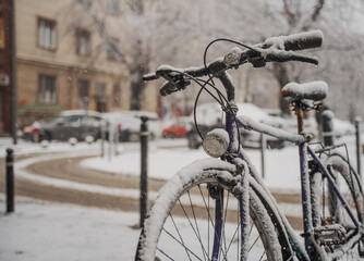 Old retro bicycle in the snow on the city streets
