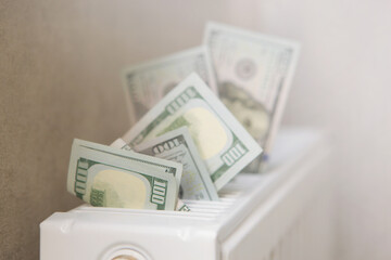 dollar bills on the background of the radiator close-up. House heating bills