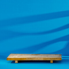 Minimalist podium on a blue background and shadows on the wall with free space 