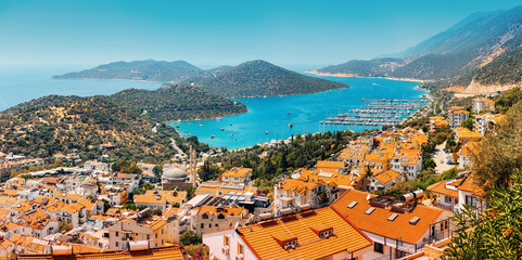 Naklejka na ściany i meble Majestic panoramic view of seaside resort city of Kas in Turkey. Romantic harbour with yachts and boats. Villas and hotels with red roofs are open for tourists