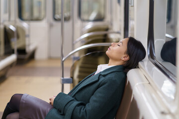 Returning home late. Empty subway wagon with sleeping african american businesswoman working in...