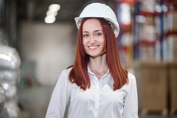 Woman in protective helmet looking at camera indoors