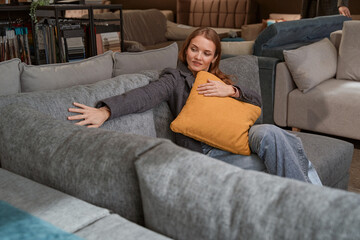 Obraz premium Concentrated lady selecting new couch in furniture store