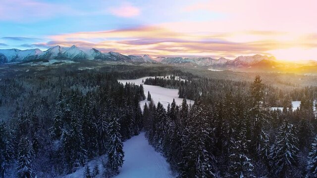 Snow capped mountains in the winter, aerial view. Aerial view of winter mountain landscape and colorful sunset sky. Tatra high mountains and magical unspoiled scenery.