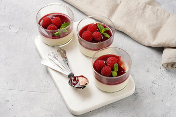 Italian dairy dessert panna cotta with raspberry jam, fresh raspberries and mint on marble board