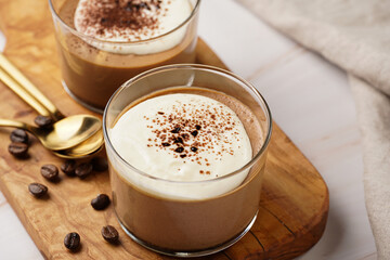 Italian chocolate and coffee mousse dessert semifreddo - half-frozen ice cream with whipped cream and cocoa powder in small glasses