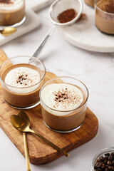 Italian chocolate and coffee mousse dessert semifreddo - half-frozen ice cream with whipped cream and cocoa powder in small glasses